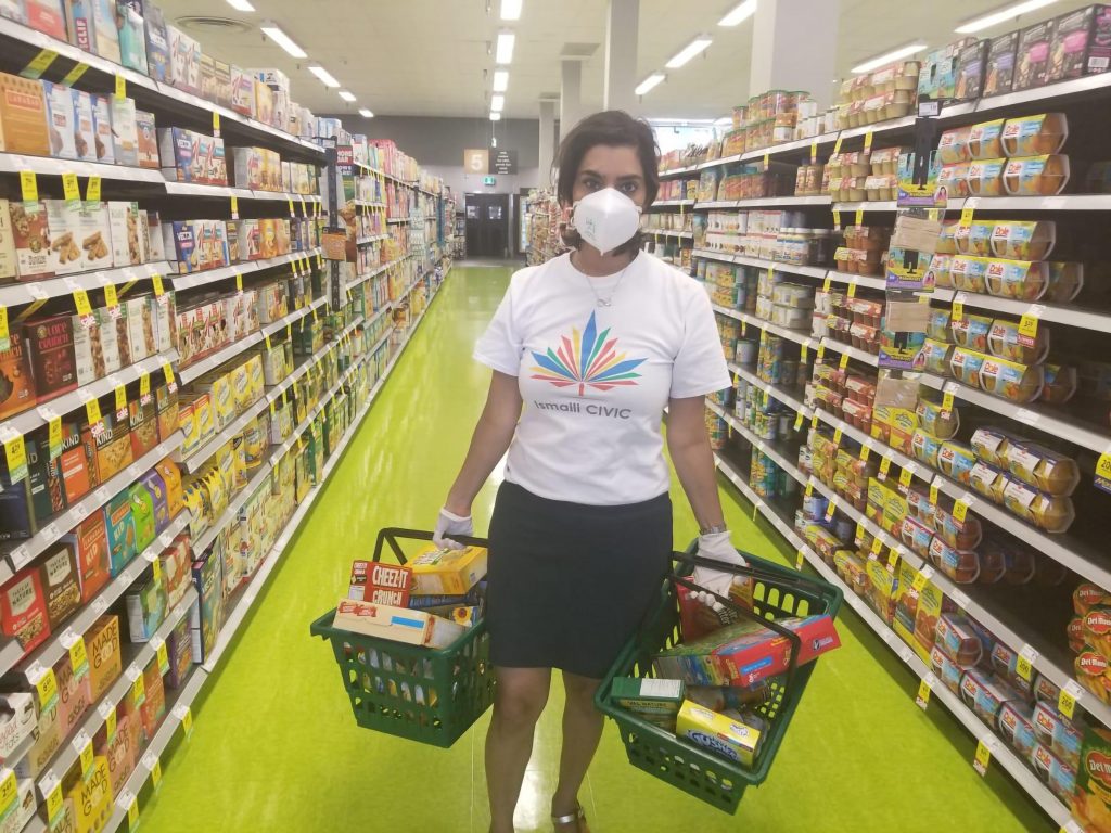 Woman carrying groceries inside a store.