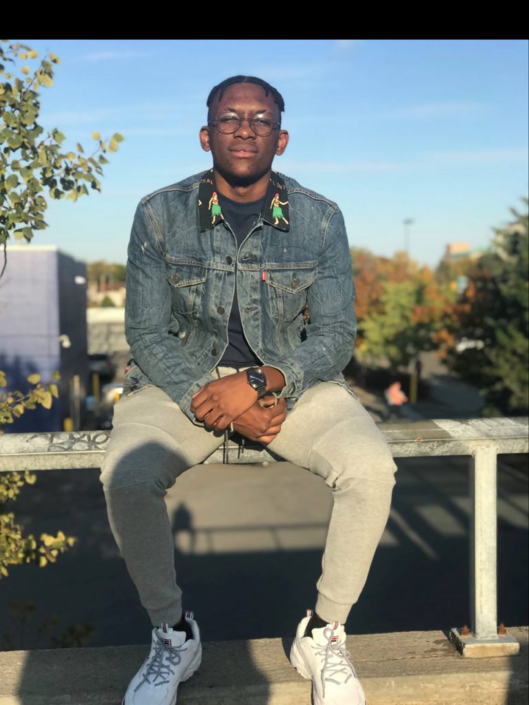 A man sits on a bench, patiently waiting.