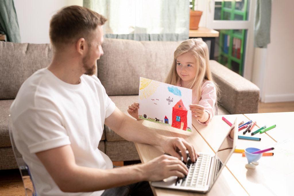 Little girl shows her father a picture she drew