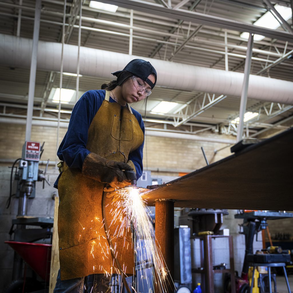 An woman learns to use a torch cutter