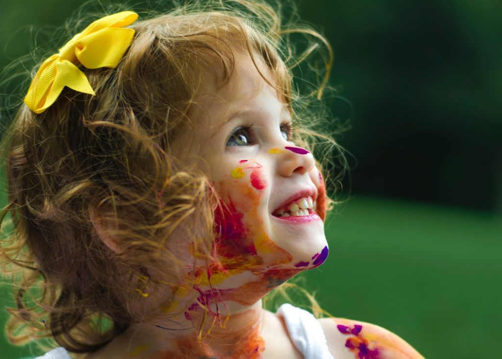Smiling little girl covered in pain